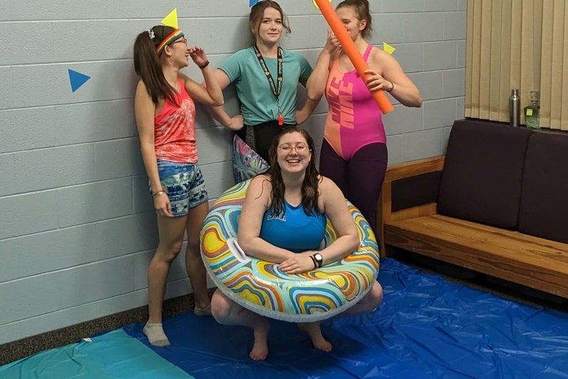 four students dressed in beach clothes posing 