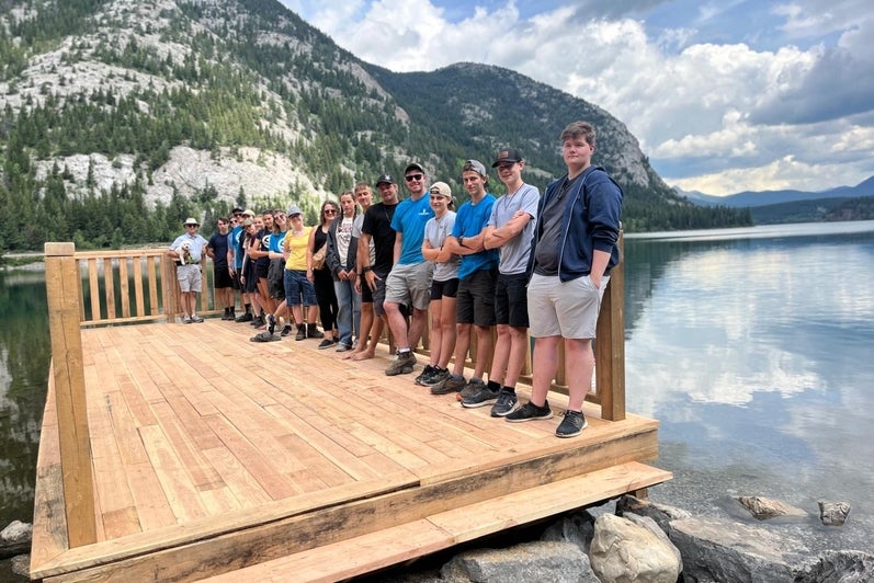 Group of MDS volunteers standing on a scenic dock in Alberta