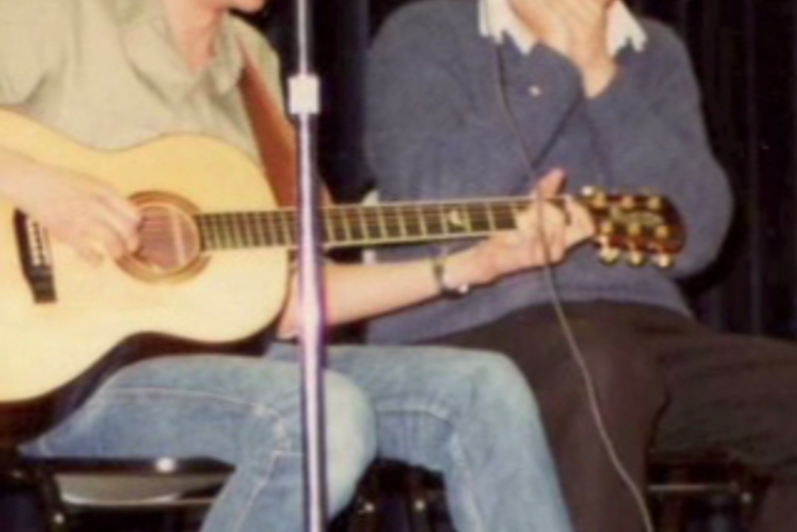 Two students play guitar on stage (80s)