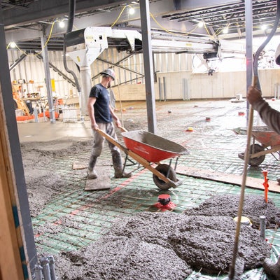 Concrete being poured from a wheel barrow in the new kitchen space