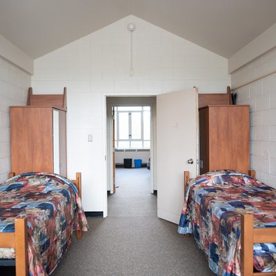a room with two beds, facing the door into the hallway