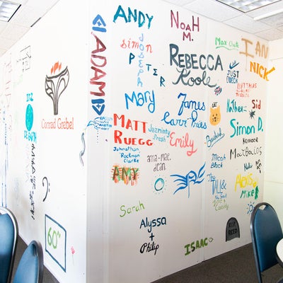 Summer students painted their names and faculty related images to a temporary wall in the cafeteria