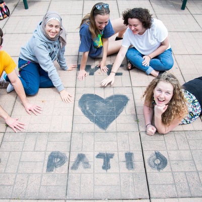 Students gather around a "we love patio" message painted on the patio. 