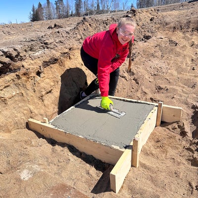 a student smoothing a concrete foundation