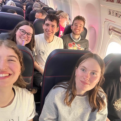 6 students smiling on an airplane