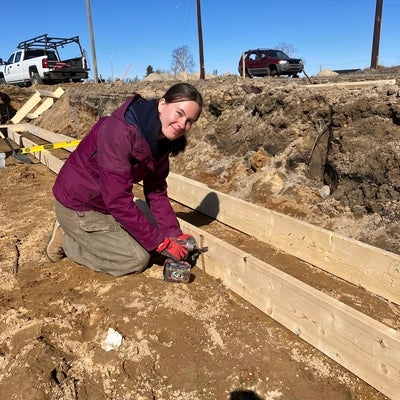 a student building a wooden frame for pouring cement