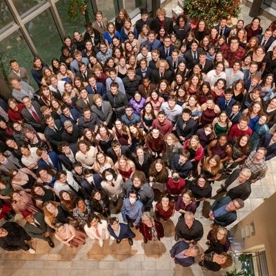 Group photo in the upper atrium, including students, staff, faculty.