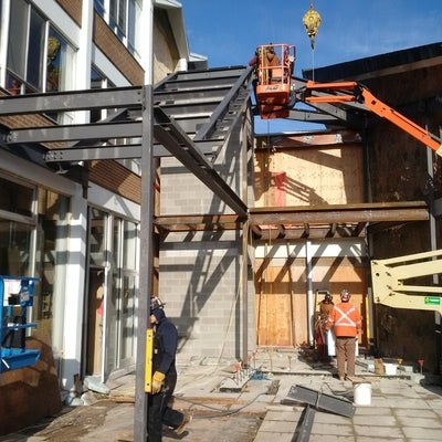 Steel beams are installed creating the structure for the new stairway on the patio