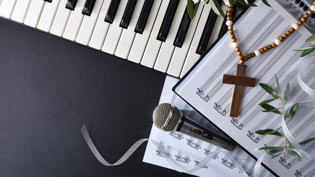piano keyboard, sheet music, microphone, and wooden cross.