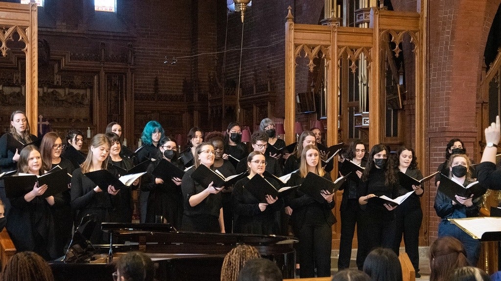 chior holding sheet music singing