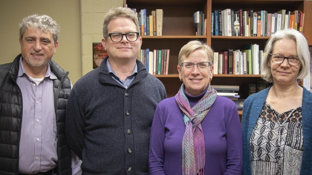 Fred, Marcus, Anita and Laureen standing beside eachother in front of a book shelf