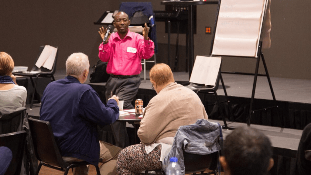 Issa Ebombolo speaking to a group