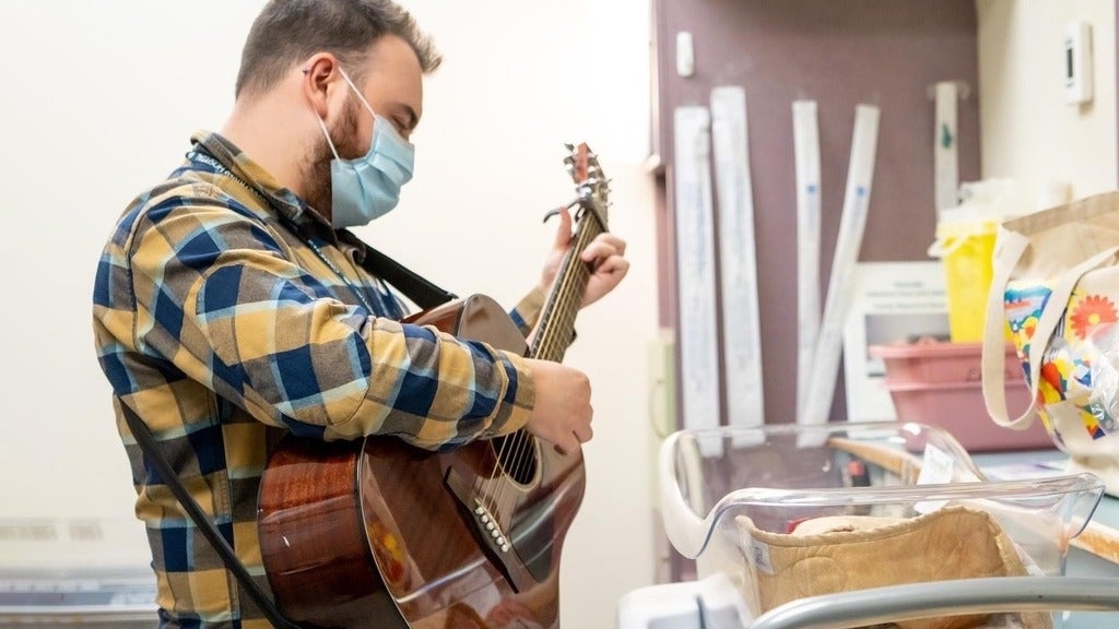Tyler Reidy playing guitar in hospital 