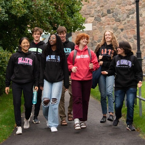 students wearing waterloo faculty shirts walk down a path at Grebel