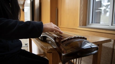 Jane playing the guqin, a traditional Chinese instrument