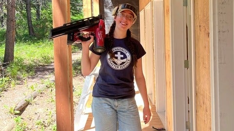 Mona Bailey on a construction site with MDS holding up a drill