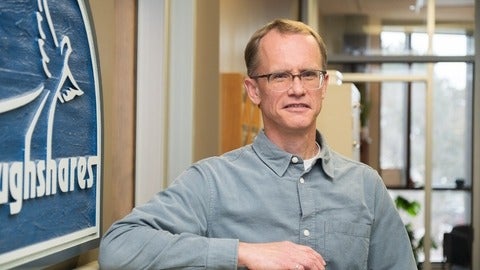 Paul Heidebrecht in front of Ploughshares sign