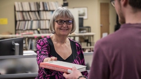  Ruth Steinman handing a book over to a student
