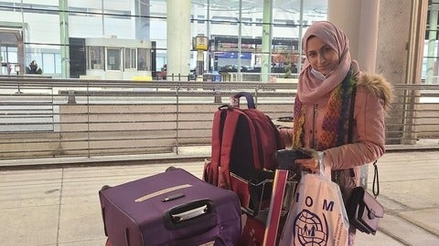 Remma standing with cart full of luggage 