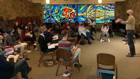 Derek preaching in front of chapel crowd 