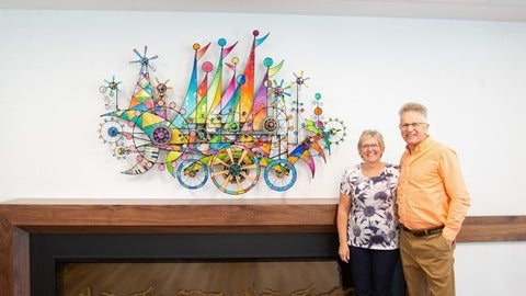 Paterson's posing beside kinetic sculpture "We Are All Engines of Joy" 