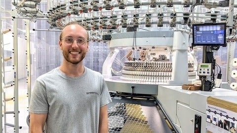Jared Baribau standing in front of various tech