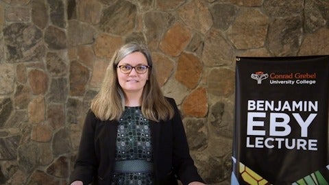 karen sunabacka standing beside sign for eby lecture