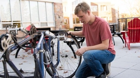 Liam holding onto his bikes wheel 