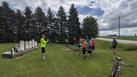 students on bikes looking at Ed Janzen