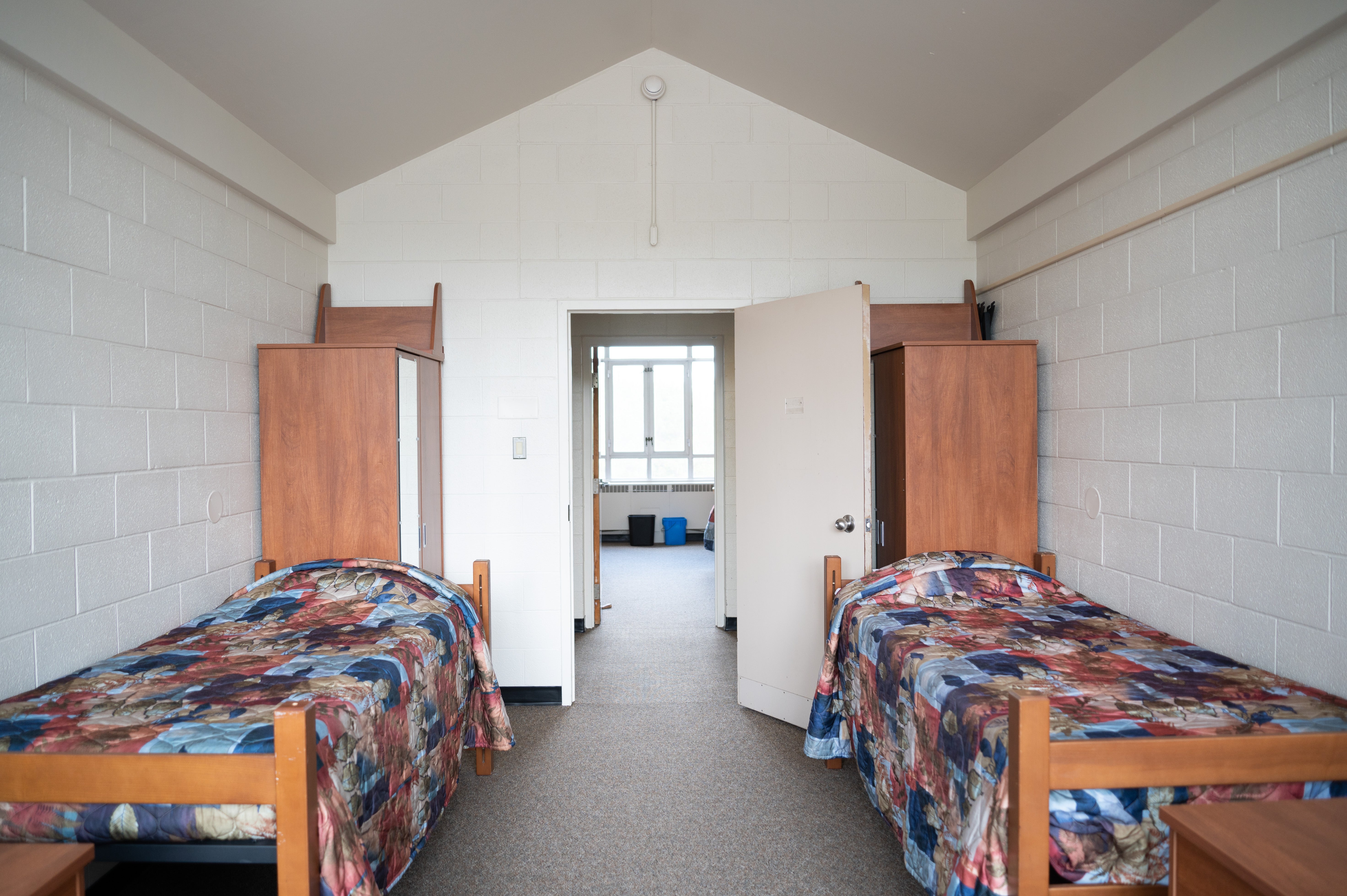 a room with two beds, facing the door into the hallway