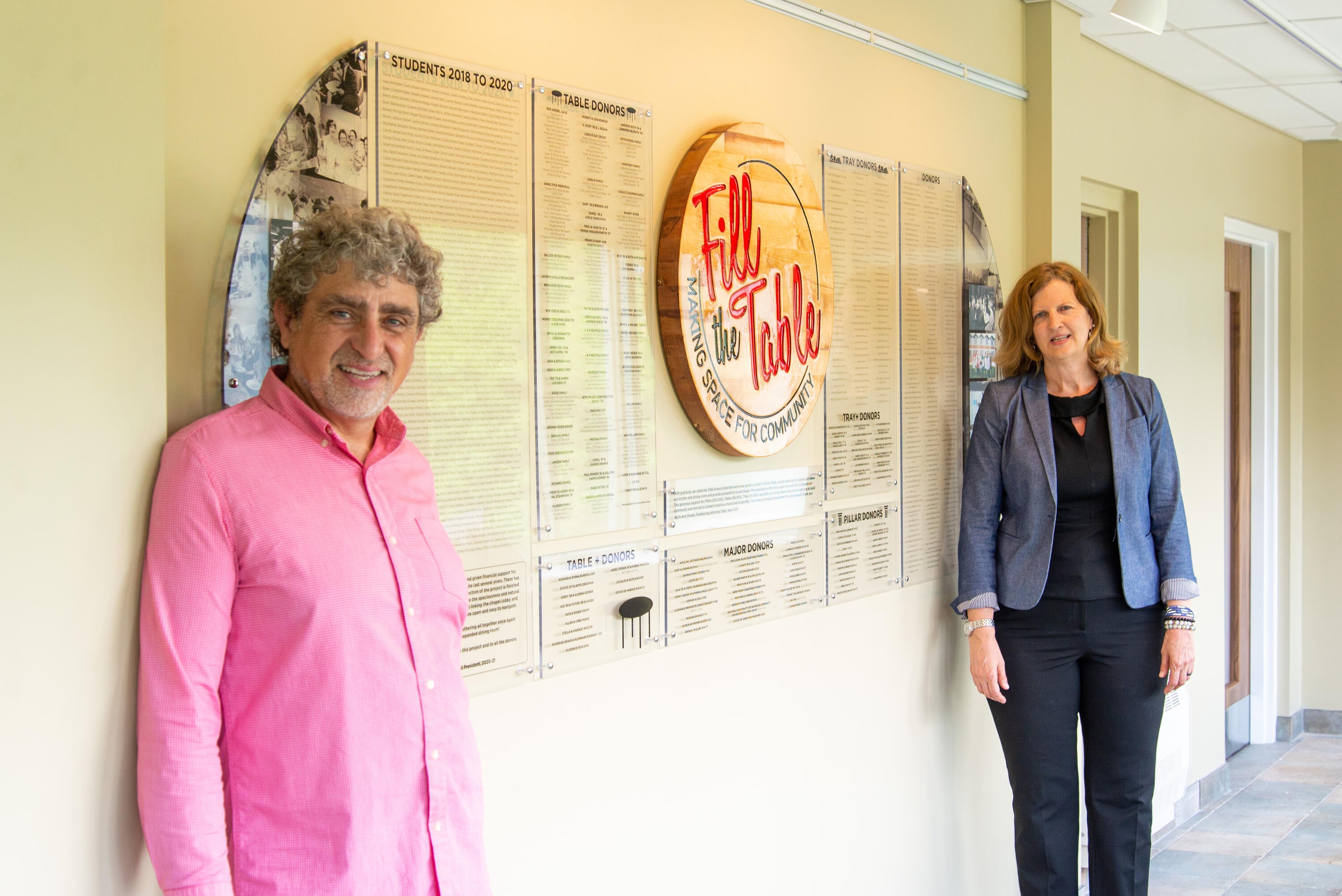 Fred and Ruth stand in front of the Donor wall