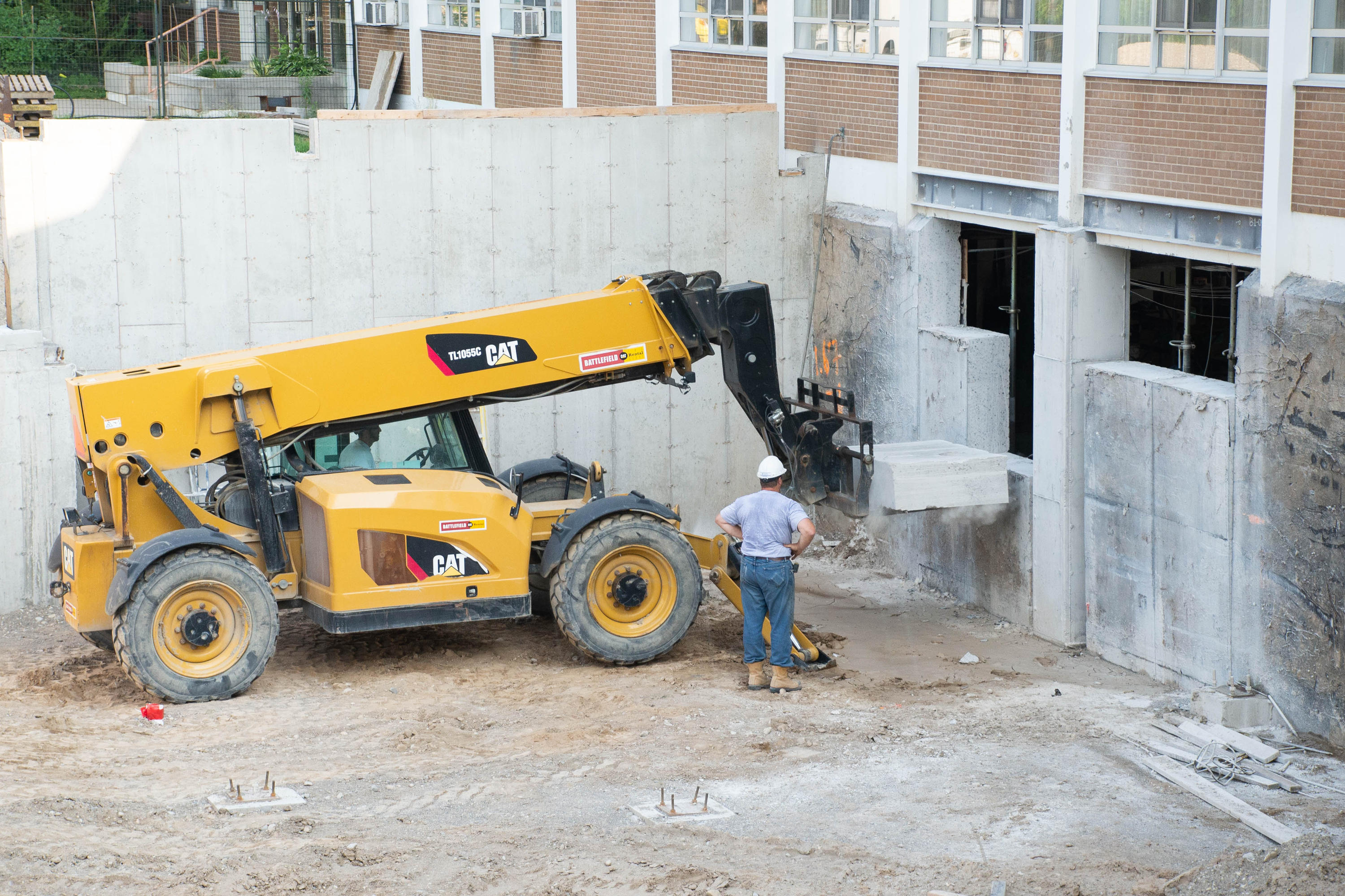 Concrete is removed from foundation by heavy machinery