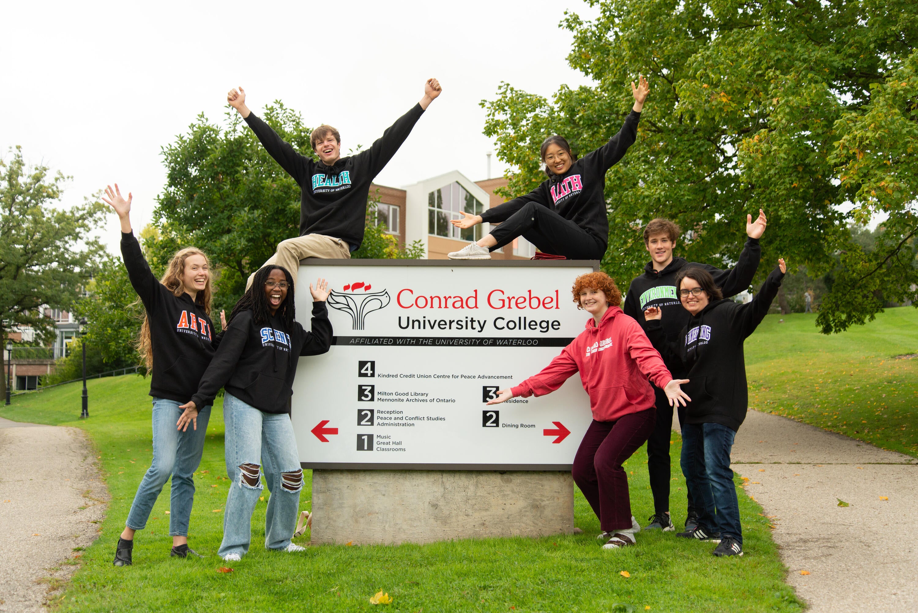 students cheer outside a grebel sign