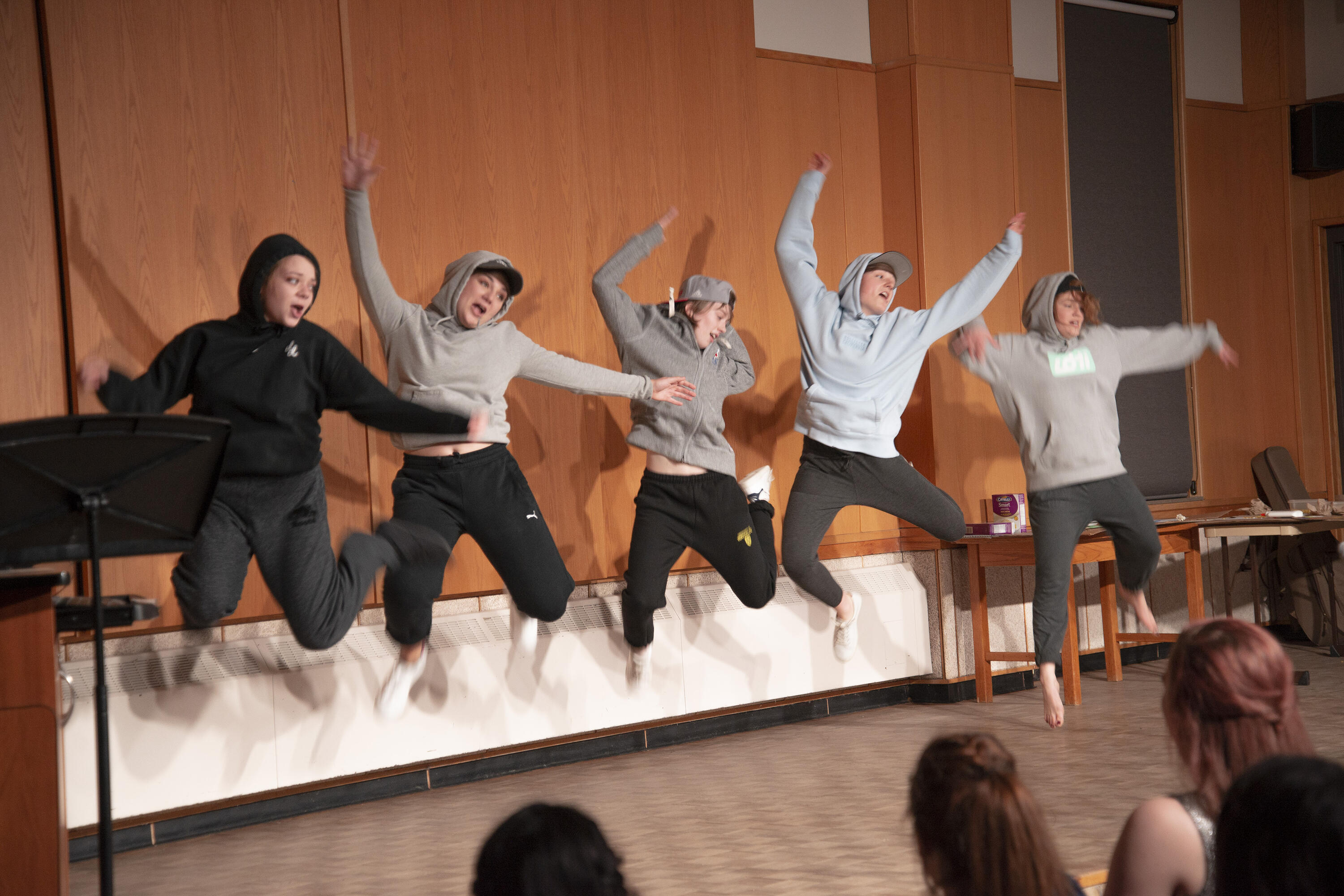 A group of students jump in the air during a talent show in the great hall