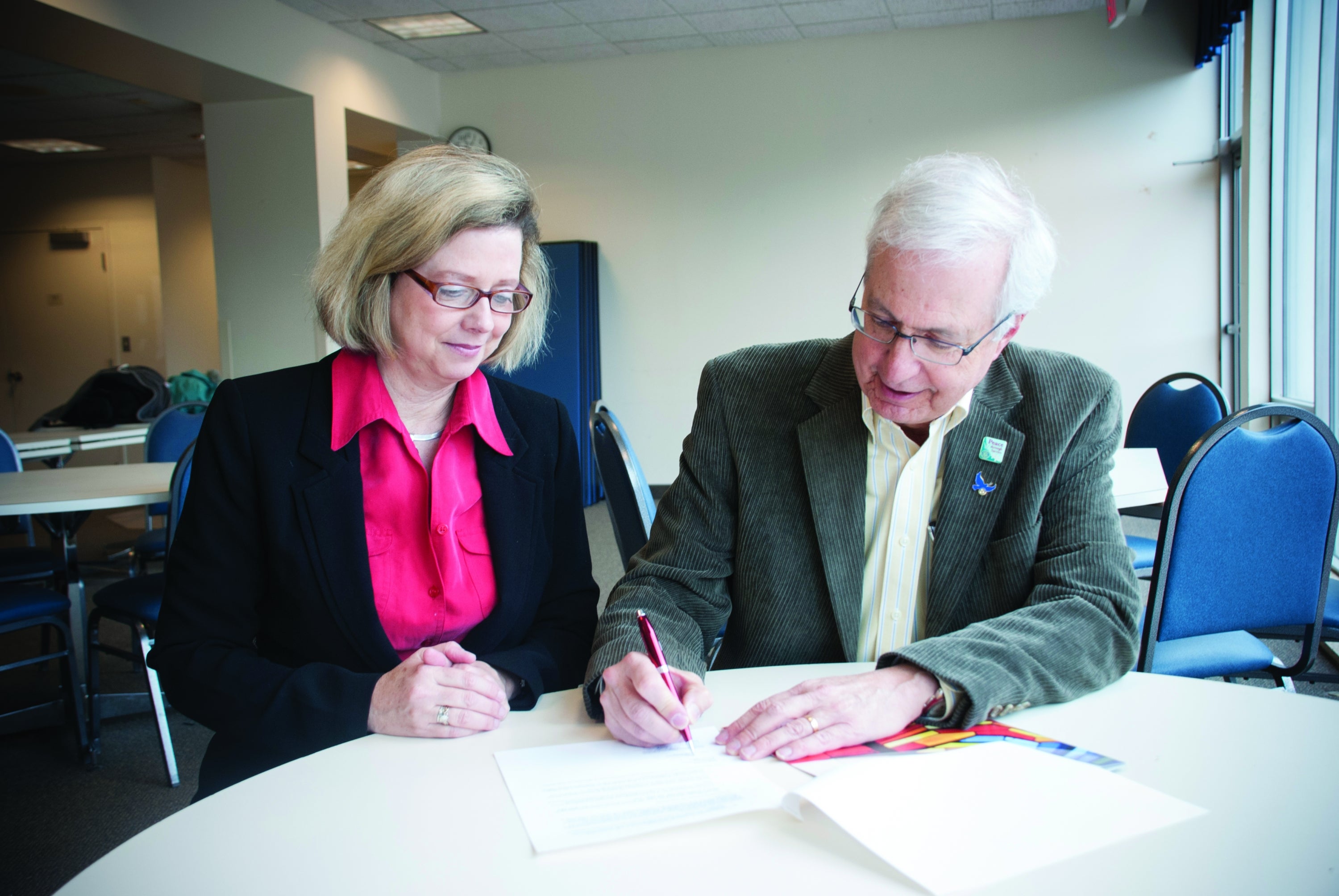 Susan Schultz Huxman and Ernie Ginsler sign the gift agreement.