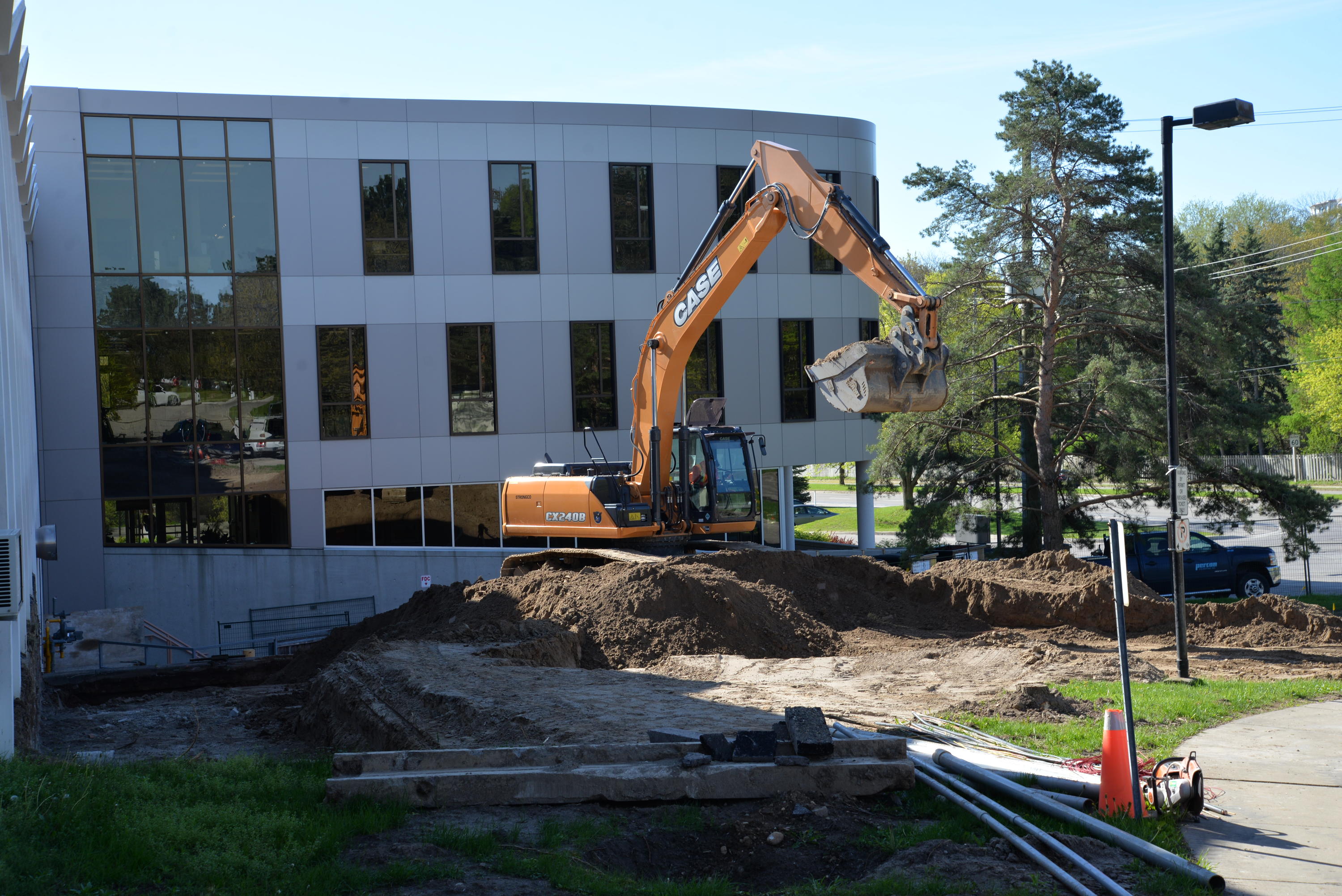 A backhoe begins digging on a bright sunny day
