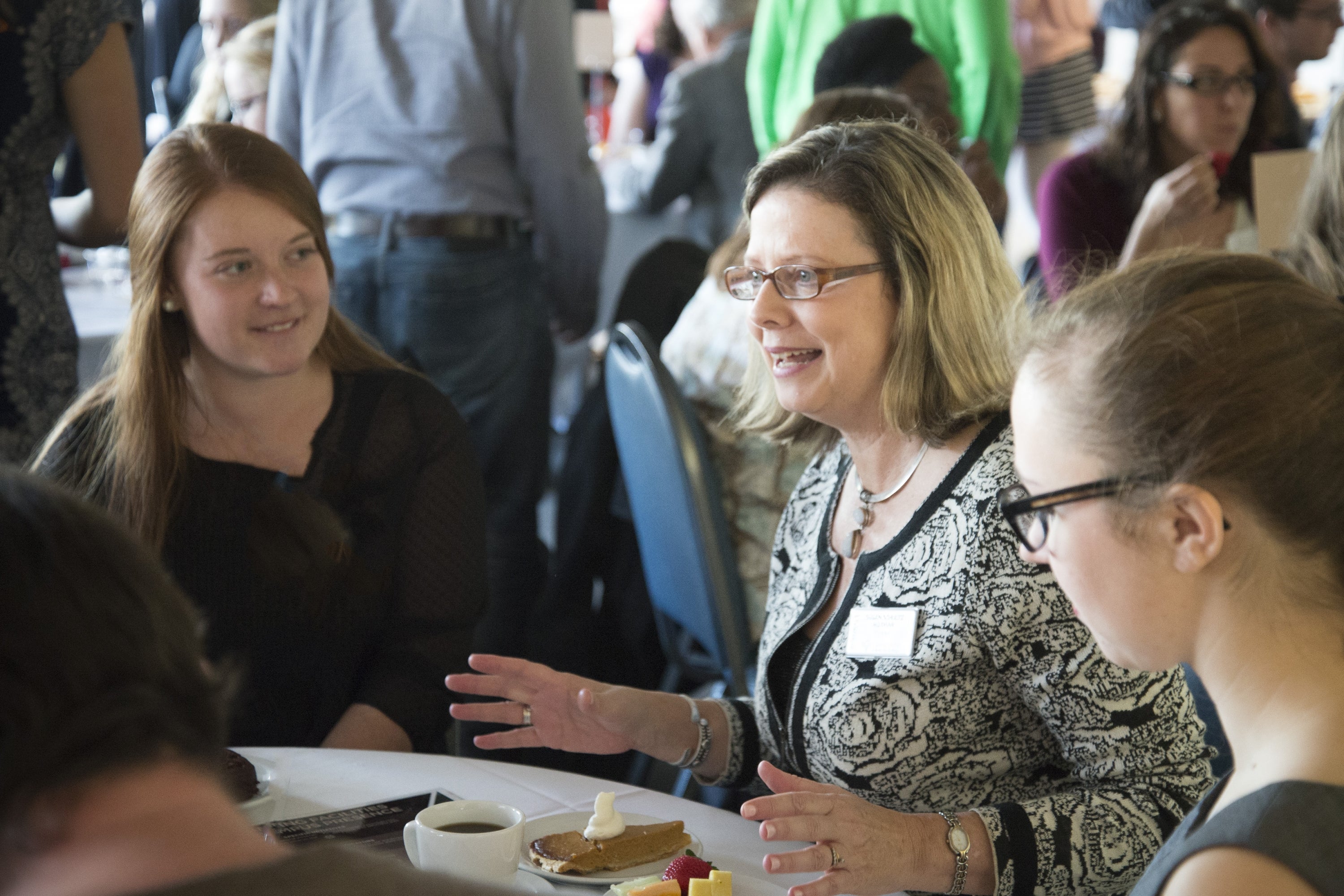 Susan Huxman , president sitting at a table with students