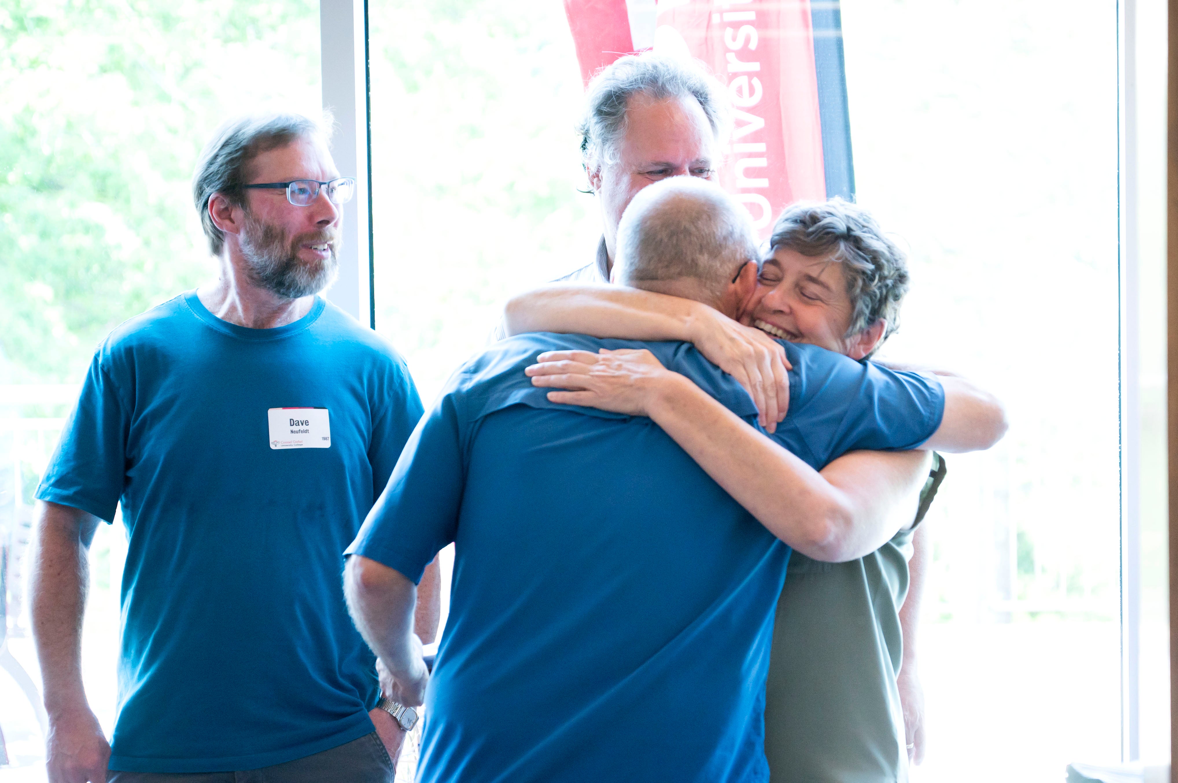 Two alumni friends hug during the 80s reunion