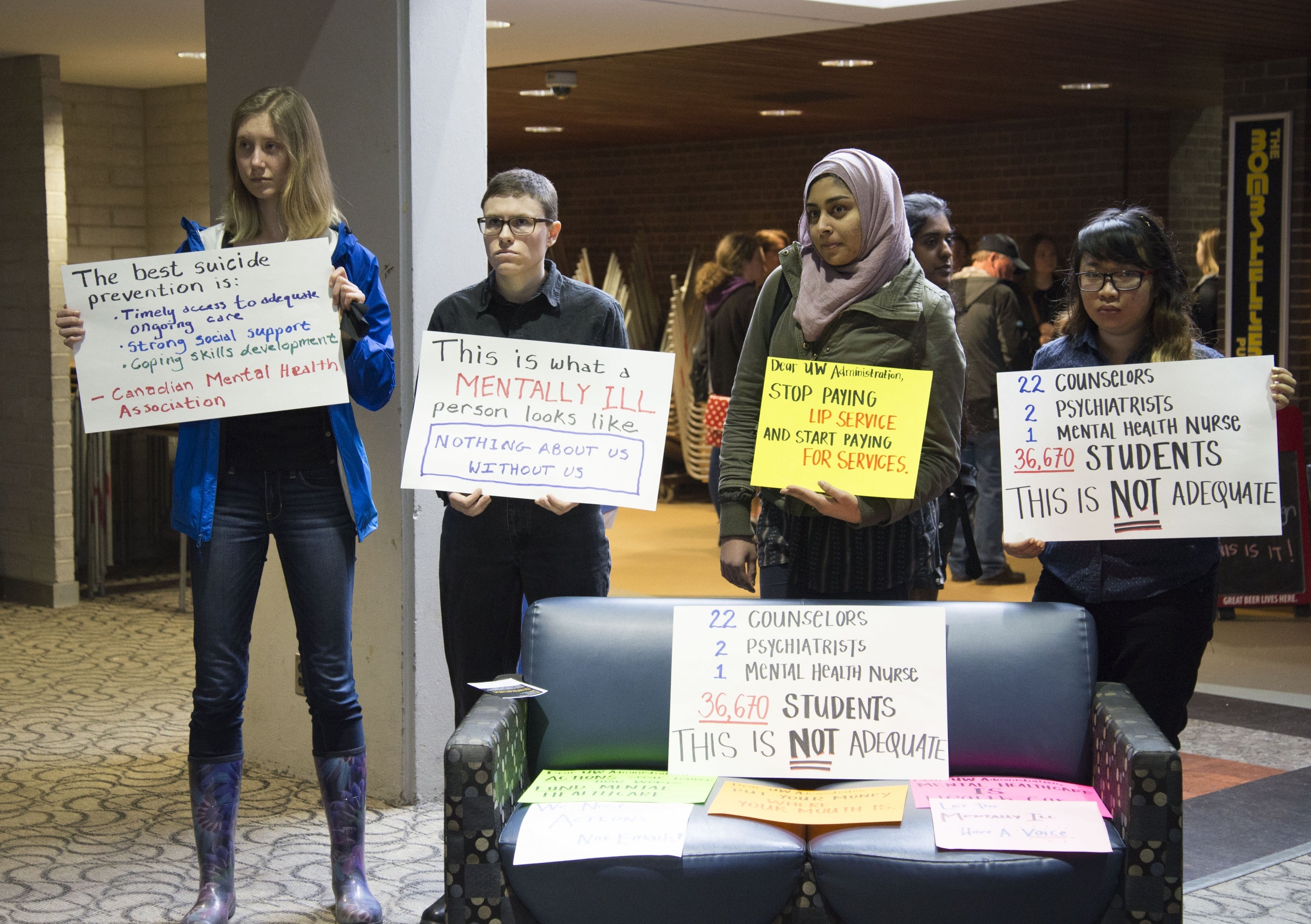 UWaterloo students hold signs to raise mental-health awareness.