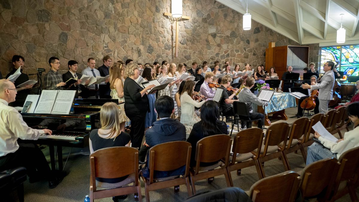 The grebel chapel full of people, a large choir and several musicians are performing