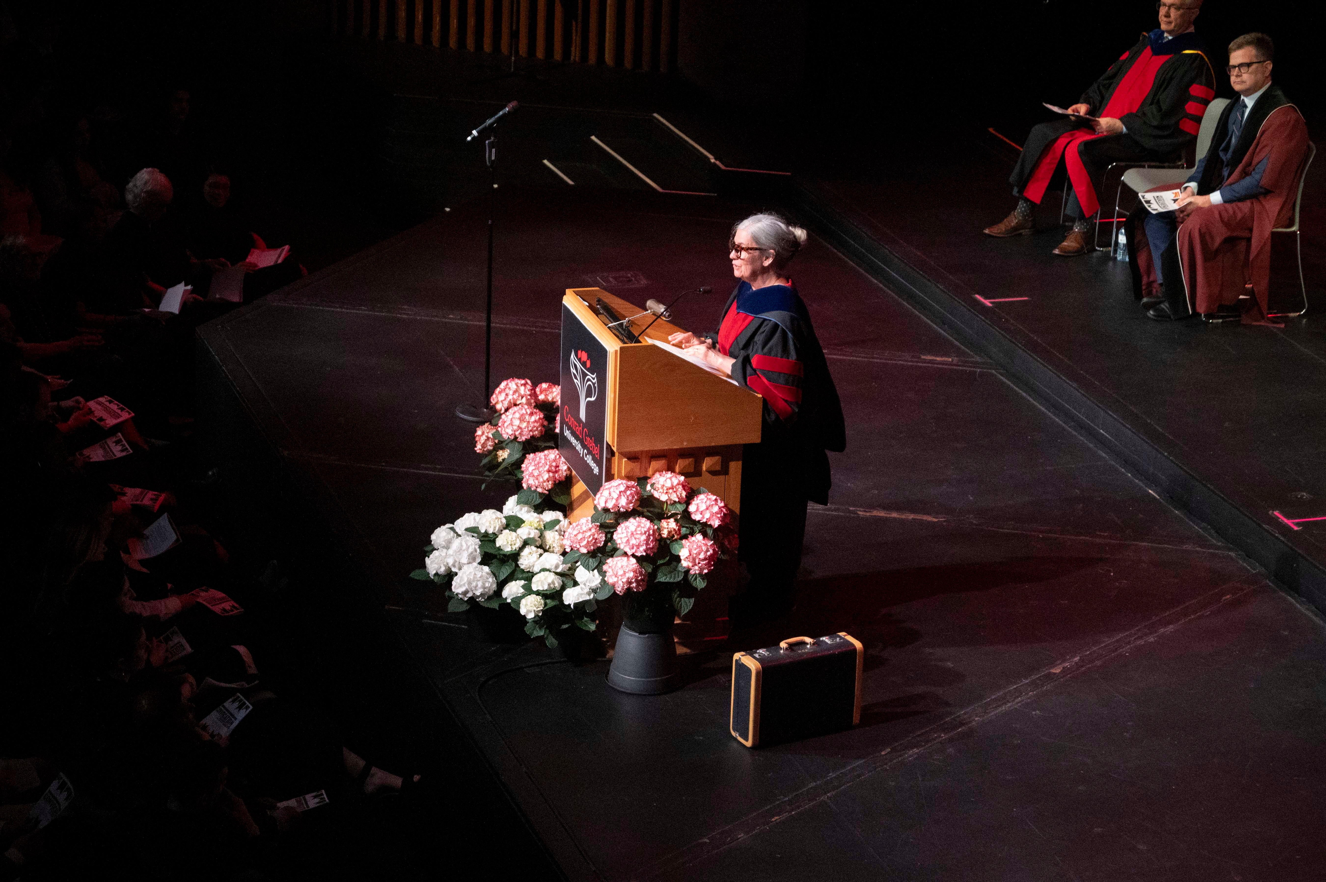 Laura Gray giving the convocation address at a podium