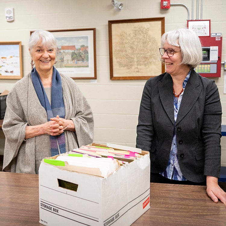 Hildi Froese Tiessen (left) and Laureen Harder-Gissing (right) look through the collection of materials.