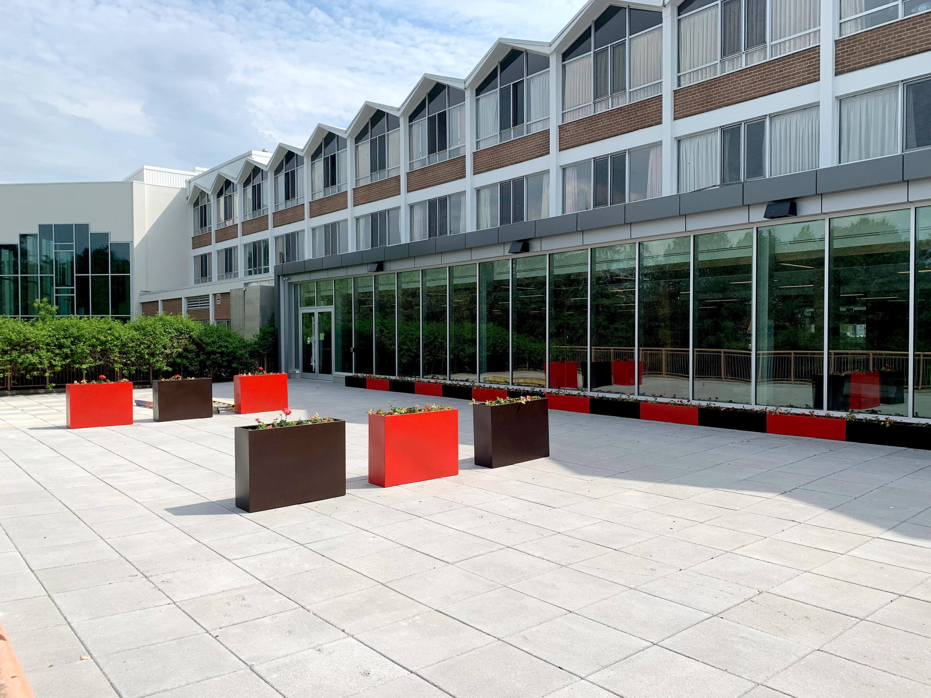 a view of the new grebel patio, facing the new dining room extension. Red and black planters sit on the stone patio