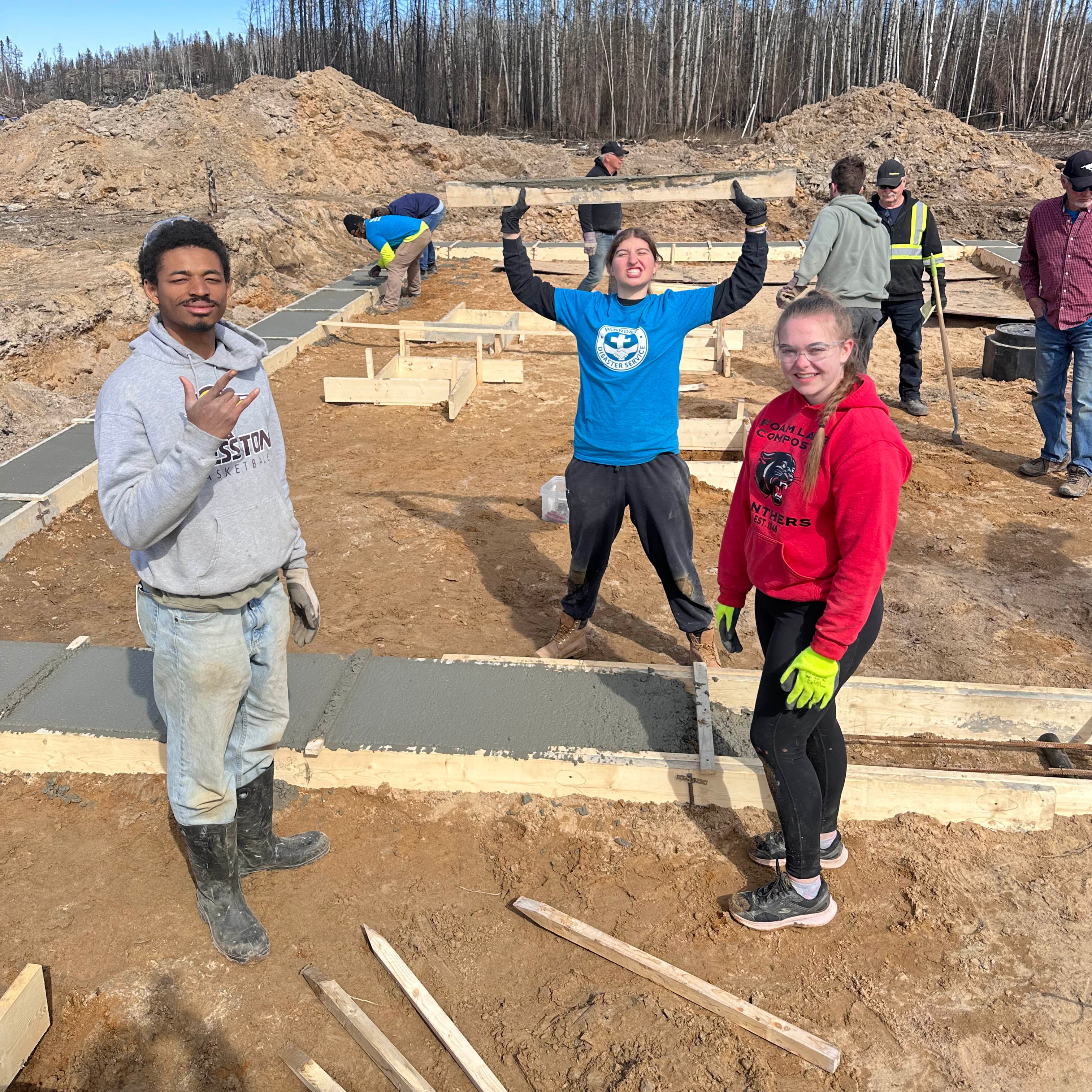 three students celebrating their new cement smoothing skills