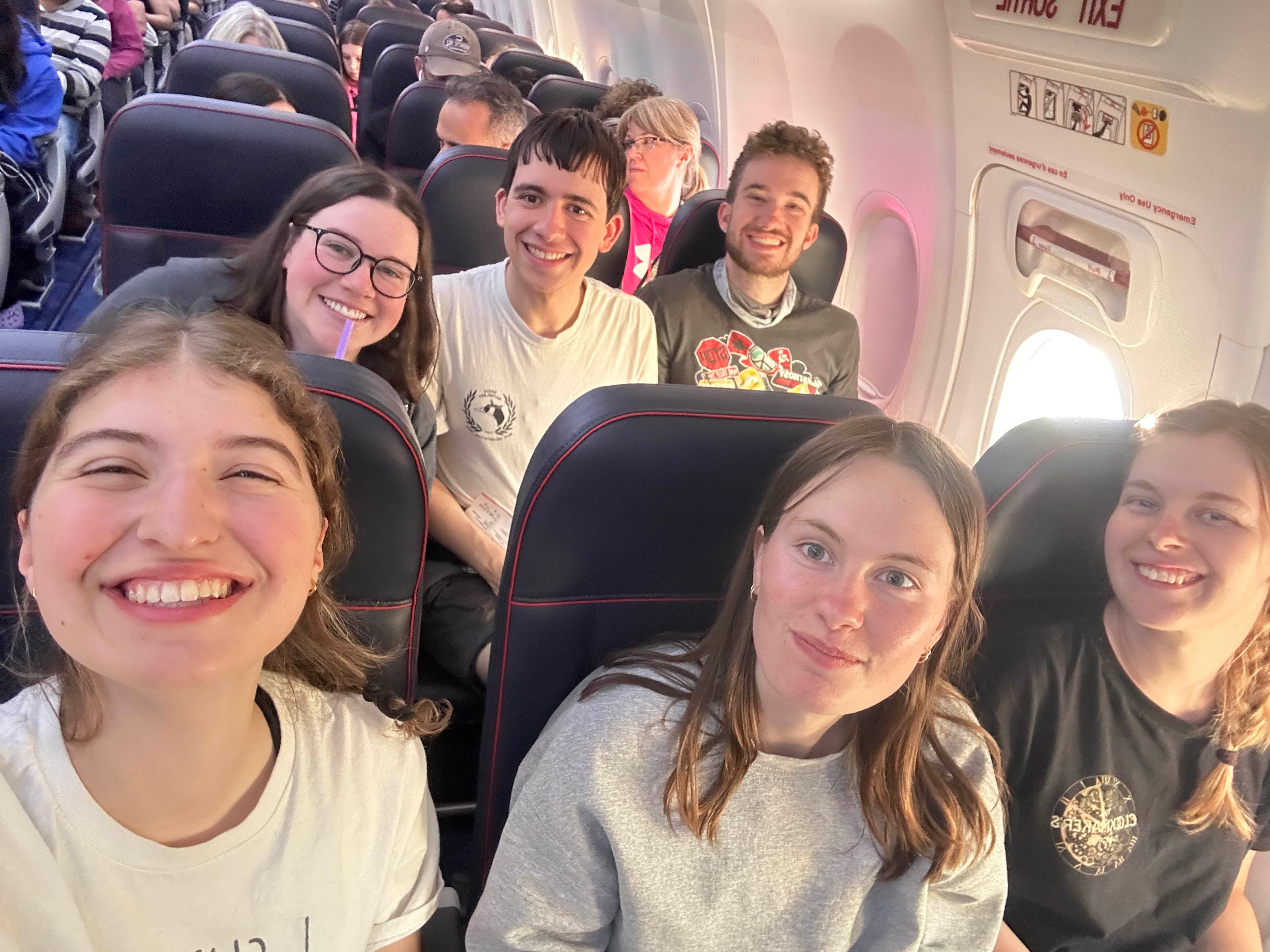 6 students smiling on an airplane