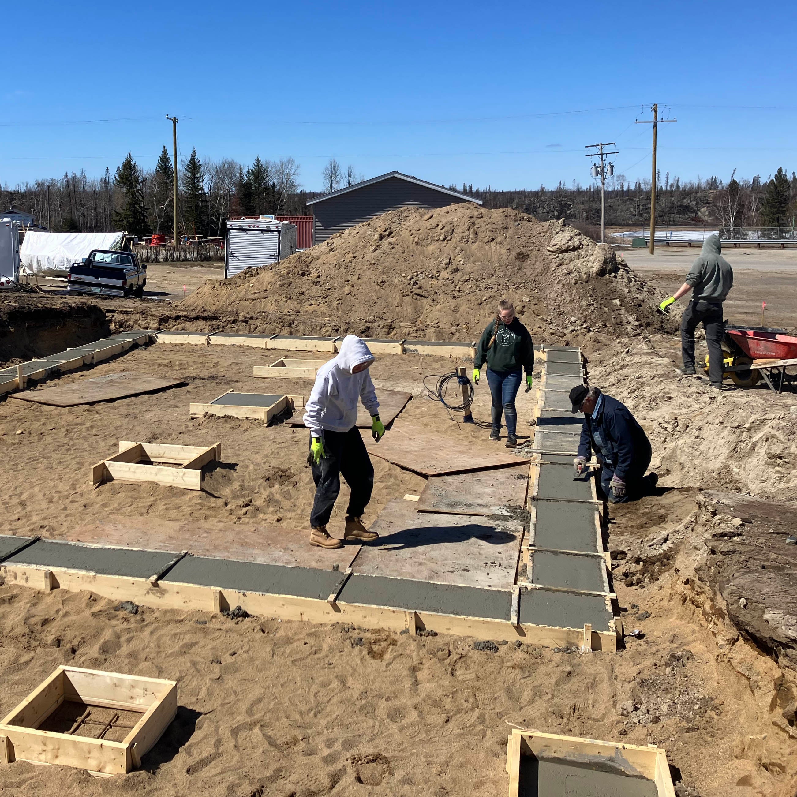 three students smoothing concrete foundations