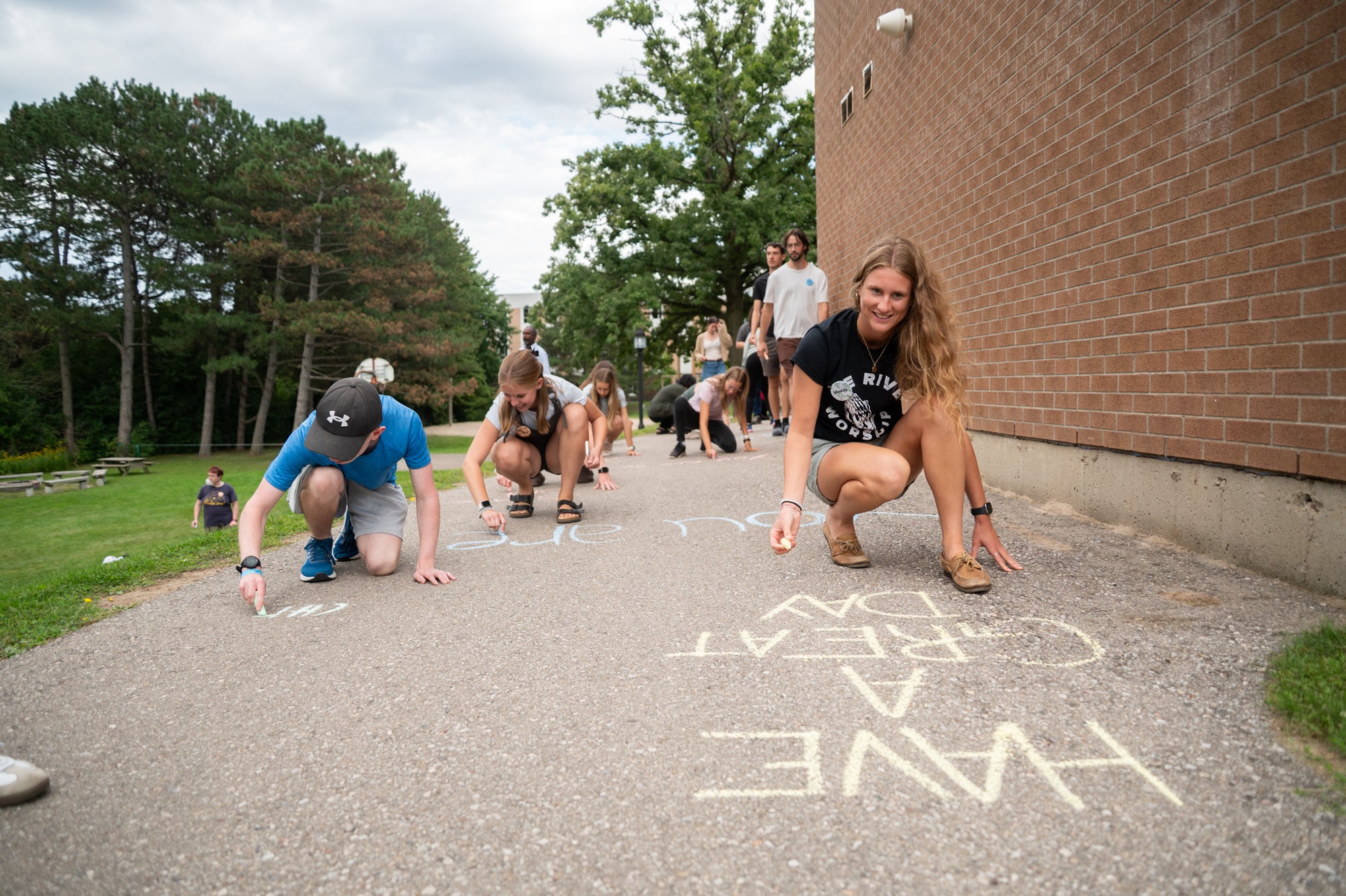 Students drawing on the grebel path with chalk