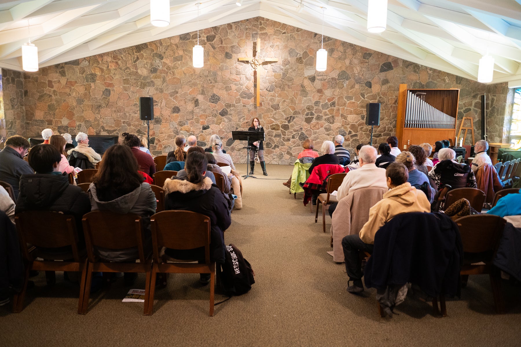 Kathryn Ladano playing clarinet with crowd in chapel
