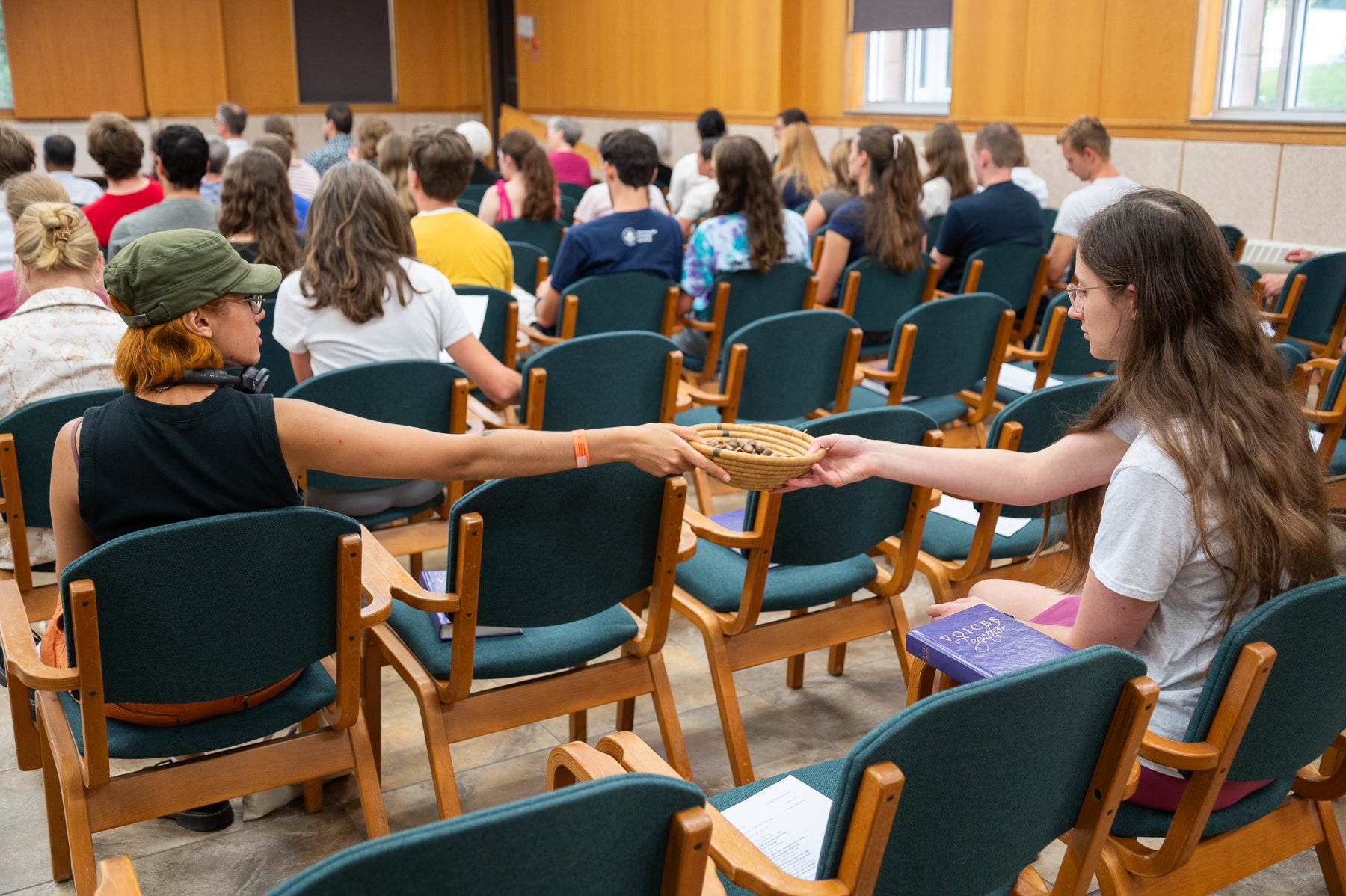 Students pass a bowl of acorns during chapel