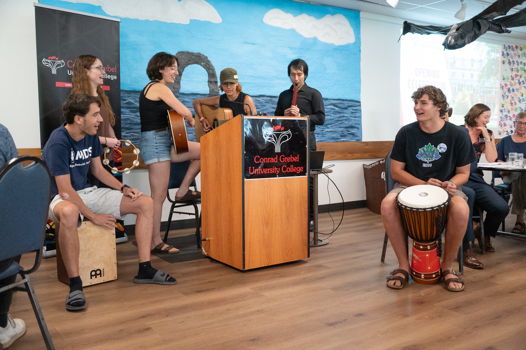 A group of students play guitars, drums, during opening celebrations